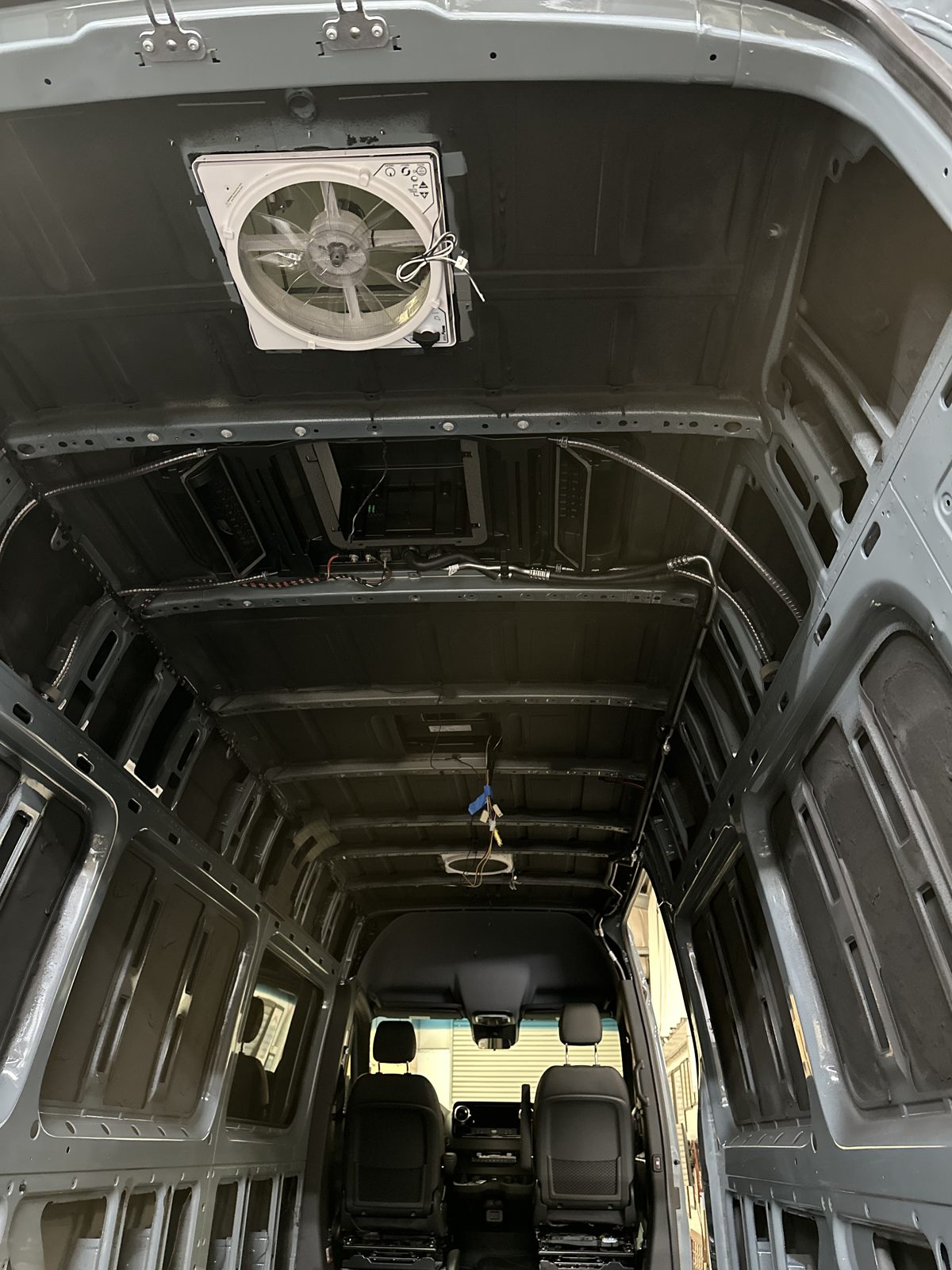 Bare Sprinter shell with MaxxAir fan installed in the roof
